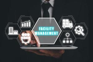 Facility management concept, Businessman using tablet with facility management icon on virtual screen. photo