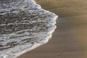 waves with white foam at the beach on vacation in egypt photo