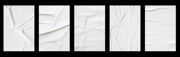 white crumpled and creased glued paper poster set isolated on black background photo