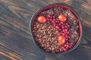 Bowl of red quinoa with nuts and sun-dried tomatoes photo