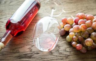 copa de vino rosado con racimo de uva foto