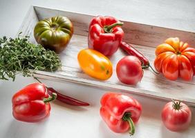 Fresh tomatoes and peppers on the wooden tray photo