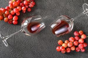 dos lentes de rojo vino con manojo de uvas foto