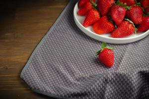 Juicy organic strawberries on gray tablecloth with copy space on background photo