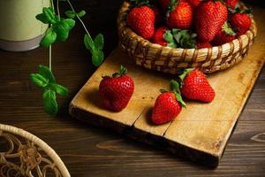 Strawberries in wooden bowl. Fresh nice strawberries on wooden table. photo