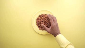 young man taking fresh almond close up video