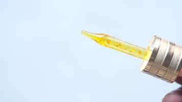 Drop falls from a pipette into a cosmetic bottle isolated on white video