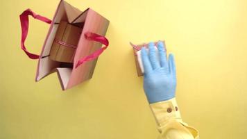 hand hold homemade gift box against yellow background video