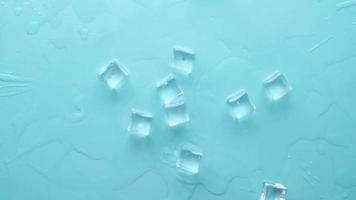 close up of many ice cubes drops on blue background video