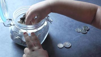 enfant fille économie pièces de monnaie dans une pot video