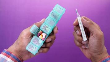 medical thermometer and pill box on color background video