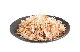 a pile of dry bonito fish flake katsuobushi in dish isolated on white background. heap of dry bonito fish flake katsuobushi isolated. bonito fish flake katsuobushi isolated photo