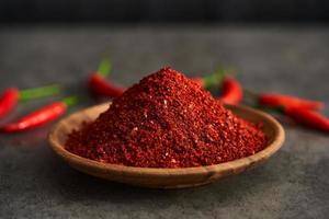 red chili pepper flake or ground powder coarse in wood bowl on gray stone food background. red chili pepper flake or ground powder coarse food. red chili pepper flake or ground powder coarse photo