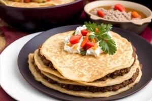 Russian cuisine. Meat dumplings stuffed with vegetables and sour cream. Pancakes with minced meat and vegetables. photo