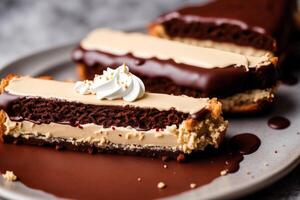 Delicious Chocolate cake with cream and icing sugar on a white plate. Eclairs with chocolate cream and cherry, photo