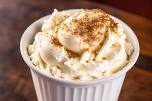 Iced coffee with whipped cream in a glass on a wooden table. photo