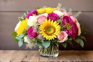 Bouquet of colorful flowers in vase on wooden background. photo