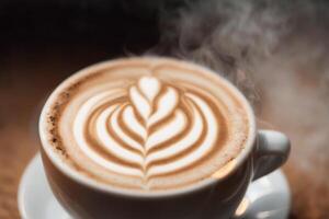 Cup of cappuccino with latte art on wooden background. photo