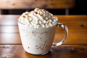 Iced coffee with whipped cream in a glass on a wooden table. photo