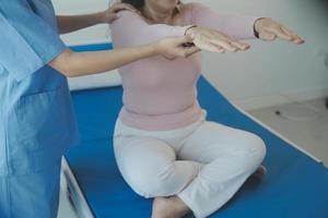 Patient doing some special exercises under supervision in a room photo