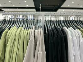 Clothes on hangers in the store. Large assortment of shopping fashion. An image of a wardrobe. photo