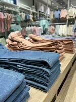 Clothing store denim pants. Large assortment of colorful clothes. photo