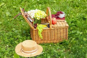 verano soleado día y picnic cesta. almuerzo en el parque en el verde césped foto