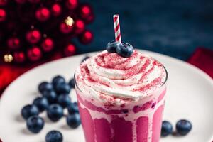 A glass of milkshake with whipped cream and blackberries.Strawberry milkshake, Raspberry milkshake. photo