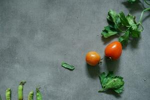 fresh tomatoes and fresh vegetables from top view on concerete background photo