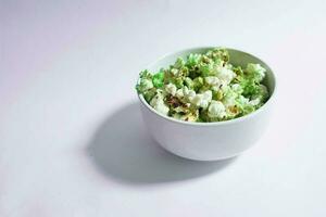 verde palomitas de maiz en un blanco cuenco en un llanura antecedentes foto