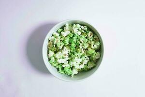 verde palomitas de maiz en un blanco cuenco en un llanura antecedentes foto