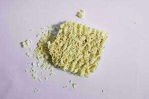 Raw yellow instant noodles ready to cook on a plain background photo