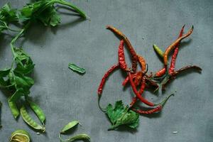 red chili with celery leaves on concrete floor photo