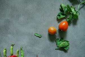 fresh tomatoes and fresh vegetables from top view on concerete background photo