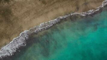 parte superior ver de el Desierto playa en el atlántico océano. costa de el isla de tenerife aéreo zumbido imágenes de mar olas alcanzando apuntalar video