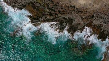 oben Aussicht von ein verlassen Küste. felsig Ufer von das Insel von Teneriffa, Kanarienvogel Inseln, Spanien. Antenne Drohne Aufnahmen von Ozean Wellen erreichen Ufer video