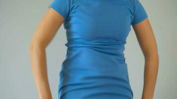 mujer en adelgazar bragas usa un azul vestir en parte superior y cheques el resultado. concepto de aspiración para un Perfecto cuerpo. de cerca video