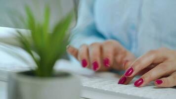 hembra manos con brillante manicura mecanografía en un computadora teclado video