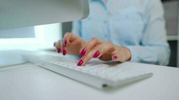 fêmea mãos com brilhante manicure digitando em uma computador teclado video