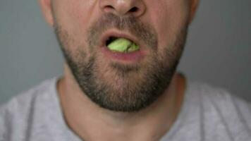 Man eating spinach shawarma with chicken and vegetables close-up video