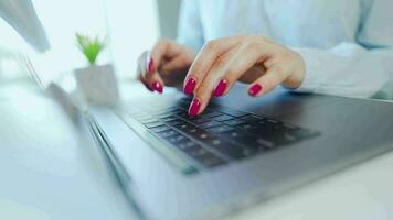 fêmea mãos com brilhante manicure digitando em uma computador teclado video