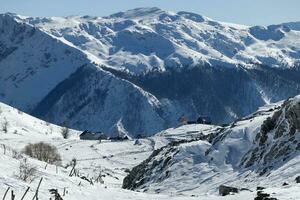 aéreo zumbido ver de montaña pueblo durante invierno. nieve blanco paisaje y alpinista estilo de vida. foto