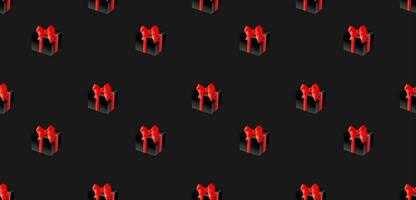 Seamless pattern of black gift boxes with red bows. vector