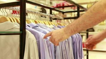 Classical shirts in clothing store, man shopping for a classic shirts in clothing store, selective focus video