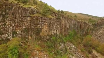 Aerial shot of solid old stone canyon, sparse plant population and nature scenery around stone canyon, selective focus video