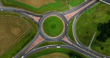 drone coup de Autoroute et intersection construit dans vert zone, Véhicules en mouvement plus de intersection et en mouvement vers principale Autoroute, sélectif concentrer video