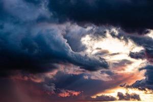 romantic western sky with sunrays and dark clouds forming the background photo