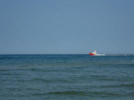 white and red sea rescue vessel sailing on the Polish Baltic Sea against the blue sky on a warm summer day photo