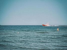 white and red sea rescue vessel sailing on the Polish Baltic Sea against the blue sky on a warm summer day photo