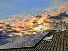 Solar panels producing clean energy on a roof of a residential house photo